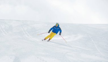 Alp kayakçısı yokuş aşağı, yüksek dağlarda kayak yapıyor.