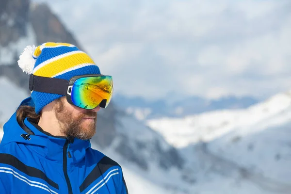 Close up portrait of man skier in hat and ski goggles mask looking at mountain range Col Gallina Cortina d\'Ampezzo Dolomites