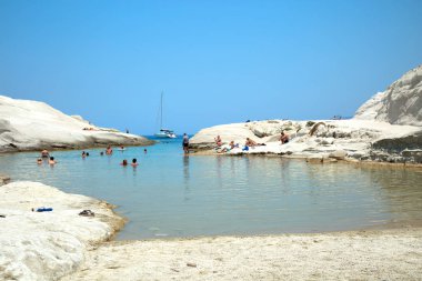 Milos, Yunanistan-Haziran 6, 2017: Sarakiniko kumsalda Miloş nerede Kuzey rüzgarları tarafından tahrik dalgalar grimsi-beyaz volkanik kaya inanılmaz şekillere şekil ve alan kez karşılaştırılır Adası manzaralarıyla