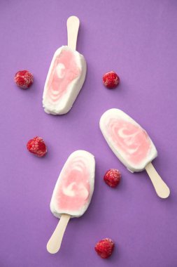 Üç meyvenin sorbe ve yoğurt ile mor bir arka plan üzerinde ahududu buzlu şeker