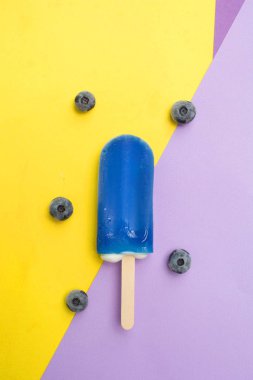 Mor ve sarı zemin üzerine taze yaban mersini ile yaban mersini buzlu şeker