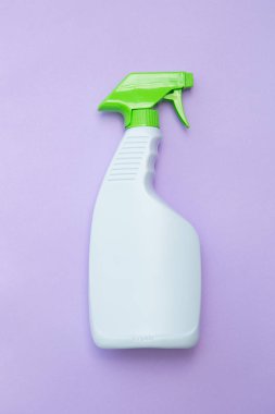 Mor bir arka plan üzerinde beyaz ve yeşil püskürtülen ilaç şişe