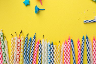 Yanan mumlar ve tutucu bir büyük Doğum günü partisi sonra sarı bir arka plan üzerinde