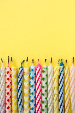 Sarı bir arka plan üzerinde yanmış mumlar