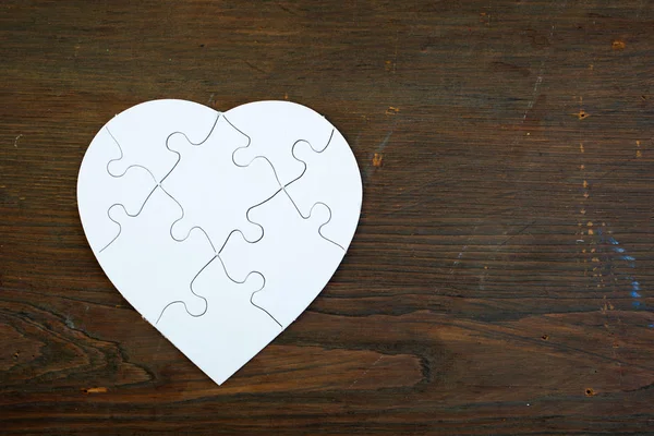 Ahşap Arka Plan Üzerinde Beyaz Puzzle Kalp — Stok fotoğraf