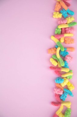 Pembe bir arka plan üzerinde farklı sakızlı şeker