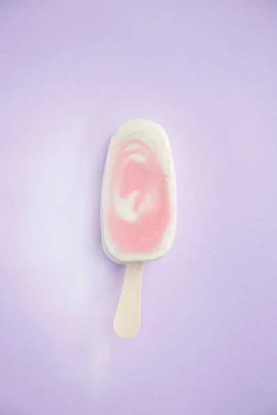 Berry sorbet and yogurt popsicle with raspberry on a lilac background