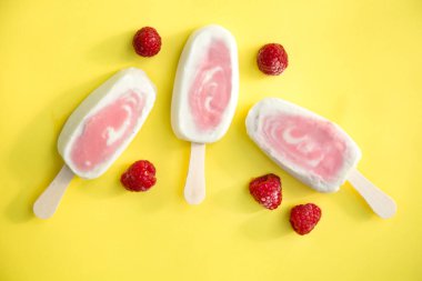 Üç meyvenin sorbe ve yoğurt ile sarı bir arka plan üzerinde ahududu buzlu şeker