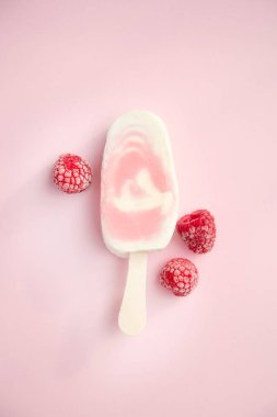 Meyvenin sorbe ve yoğurt ile soluk pembe bir arka plan üzerinde ahududu buzlu şeker