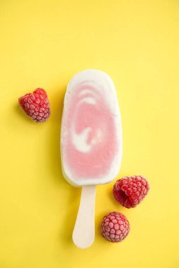 Meyvenin sorbe ve yoğurt ile sarı bir arka plan üzerinde ahududu buzlu şeker