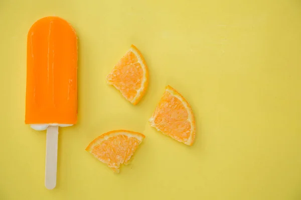 Picolé Laranja Com Poucas Fatias Laranja Fundo Amarelo — Fotografia de Stock