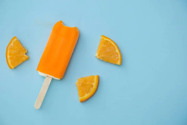 Popsicle Orange Avec Quelques Tranches Orange Sur Fond Bleu — Photo