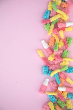 Pembe bir arka plan üzerinde farklı sakızlı şeker