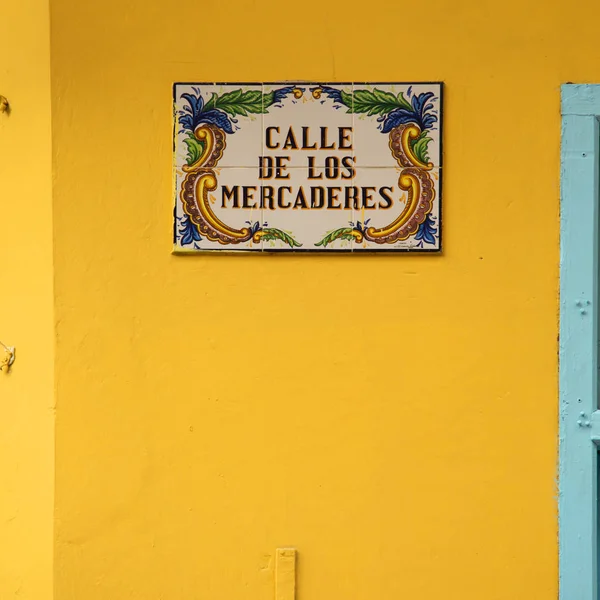 Merchant street sign on a yellow wall  in Havana Cuba,