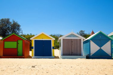 Victoria, Australi 'deki Brighton plajında arka arkaya geleneksel ve renkli küçük sahil evi.