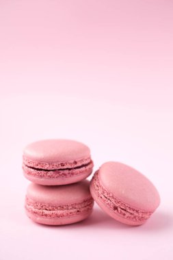 Pembe arka planda geleneksel Fransız makarnaları yığını