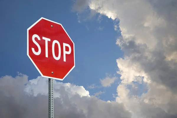 Stop Sign Against Blue Sky And Storm Clouds