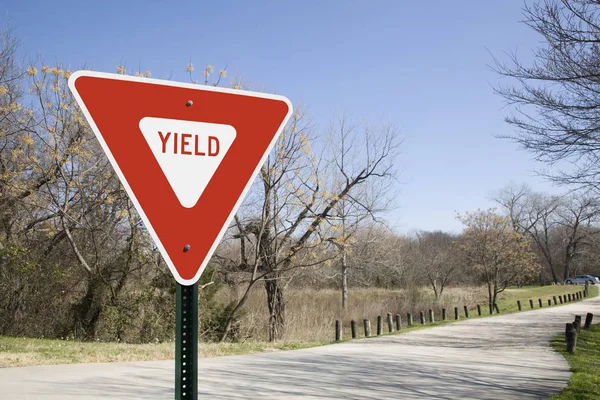 Yield Sign In Sunlight With Park Road In Winter
