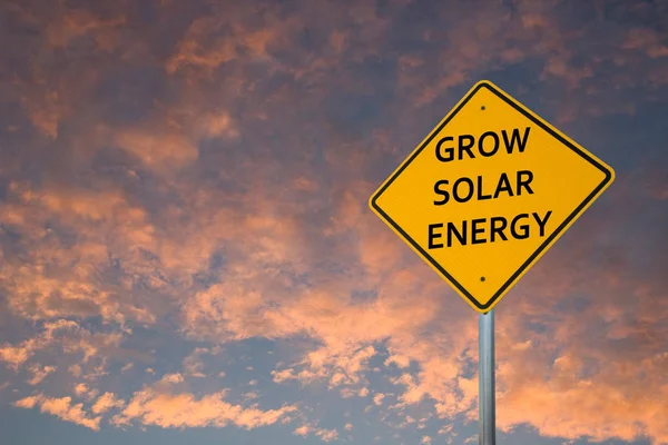 GROW SOLAR ENERGY ROAD SIGN AGAINS SUNSET CLOUDS