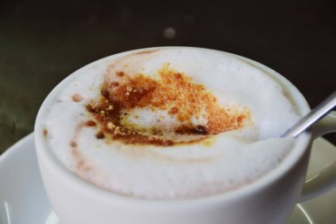 Kahve bardağı, sıcak süt çayı veya cappuccino masaya yerleştirilir