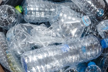 Siyah çöp torbalarındaki plastik şişeler geri dönüşüm için alınmayı bekliyor..