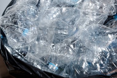 Siyah çöp torbalarındaki plastik şişeler geri dönüşüm için alınmayı bekliyor..