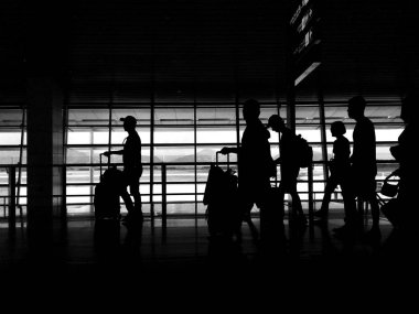 Silhouette işadamı ve Bagaj havaalanında yürüyen turist