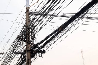 Gökyüzü günbatımı arka planında yüksek voltaj direği.