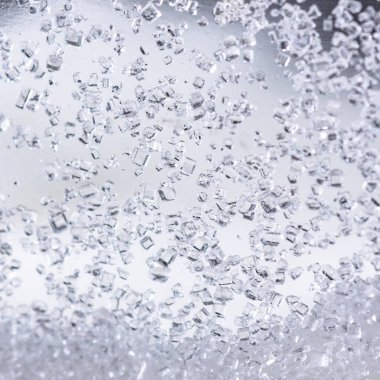 Beyaz arkaplanda cam şişelerdeki kristal şekeri kapat.