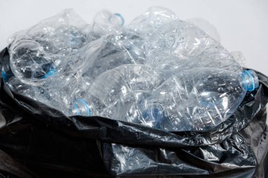 Siyah çöp torbalarındaki plastik şişeler geri dönüşüm için alınmayı bekliyor..