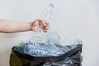 Siyah çöp torbalarındaki plastik şişeler geri dönüşüm için alınmayı bekliyor..