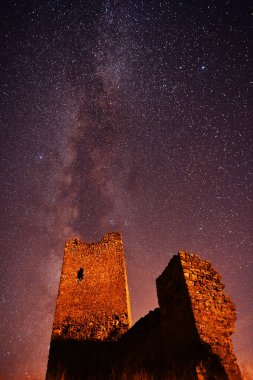 Arka planda samanyolu olan bir kale.