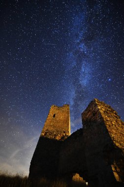 Arka planda samanyolu olan bir kale.