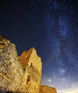 Arka planda samanyolu olan bir kale.