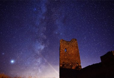 Arka planda samanyolu olan bir kale.