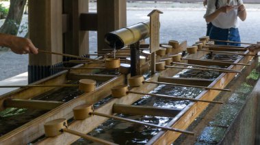 Tokyo, Japonya - Ağustos 2018: Shibuya,Tokyo'da bulunan Meiji Tapınağı'nda Temizuya veya Chozuya'da ellerini temizleyen kimliği belirsiz kişiler