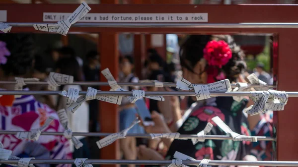 Omikuji 'yi bağlayan kızlar - Japonya, Tokyo' da güneşli bir günde Sensoji Asakusa Kannon Tapınağında Kağıt Serveti