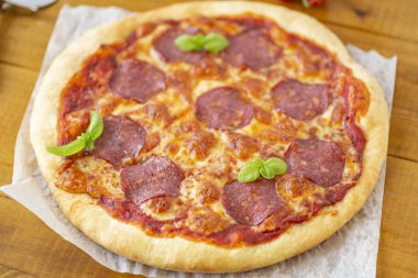 rustik pizza salam, mozzarella, zeytin ve fesleğen ile.