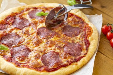 rustik pizza salam, mozzarella, zeytin ve fesleğen ile.