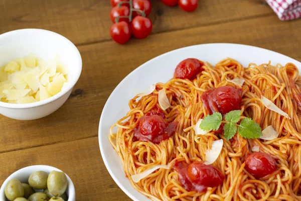 木桌上的盘子里有番茄酱的意大利面 — 图库照片