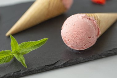 Çilekli dondurma waffle koni kayrak bir plaka üzerinde