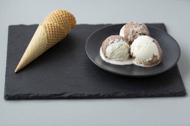 Çikolatalı ve vanilyalı dondurma, gözleme koniler, taş koyu arka plan