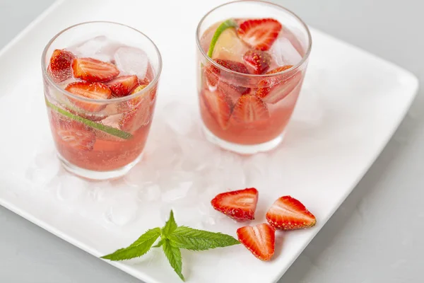 Fresh lemonade with strawberries , lime and mint. On a white background.
