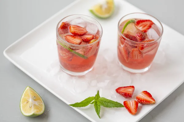 Fresh lemonade with strawberries , lime and mint. On a white background.