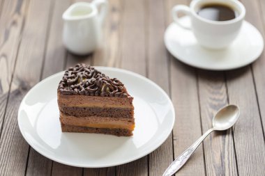 Tatlı sufle çikolata sosu ve ahşap bir masa üzerinde beyaz bir plaka üzerinde fındık ile.