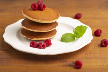 Ahududu ve ahşap zemin üzerine nane ile küçük gözleme