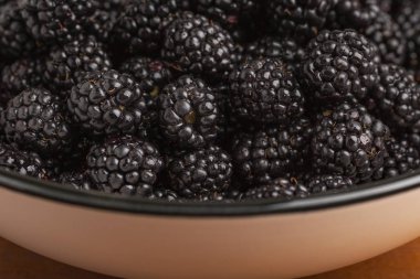 Olgun böğürtlen Kupası ahşap bir masa üzerinde. Görüntüyü.