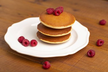 Ahududu ve ahşap zemin üzerine nane ile küçük gözleme