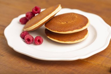 Ahududu ve ahşap zemin üzerine nane ile küçük gözleme