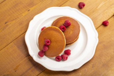 Ahududu ve ahşap zemin üzerine nane ile küçük gözleme